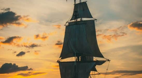 silhouette of ship on sea during sunset