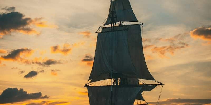 silhouette of ship on sea during sunset